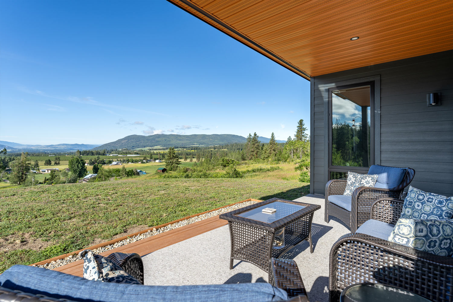 At Chaparral we love building a modular home or two. This photo highlights the patio a modular home in Armstrong BC with an exposed wooden overhang and modern grey siding.